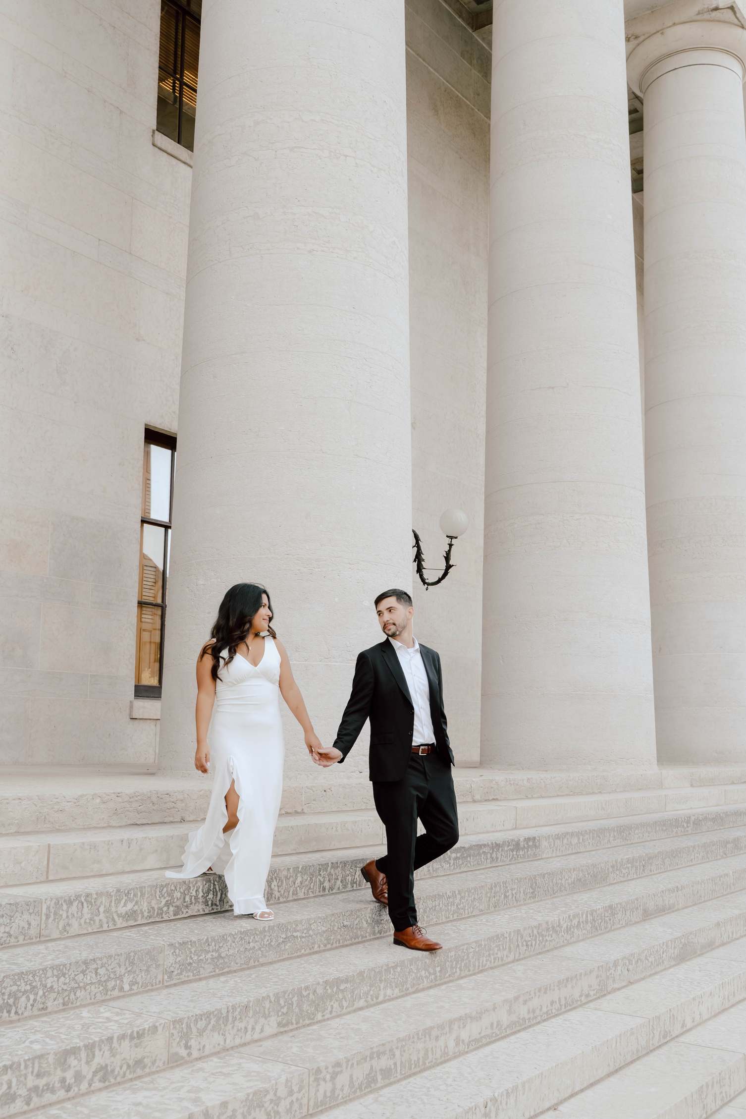 Celina and her husband holding hands at the Ohio Statehouse columns