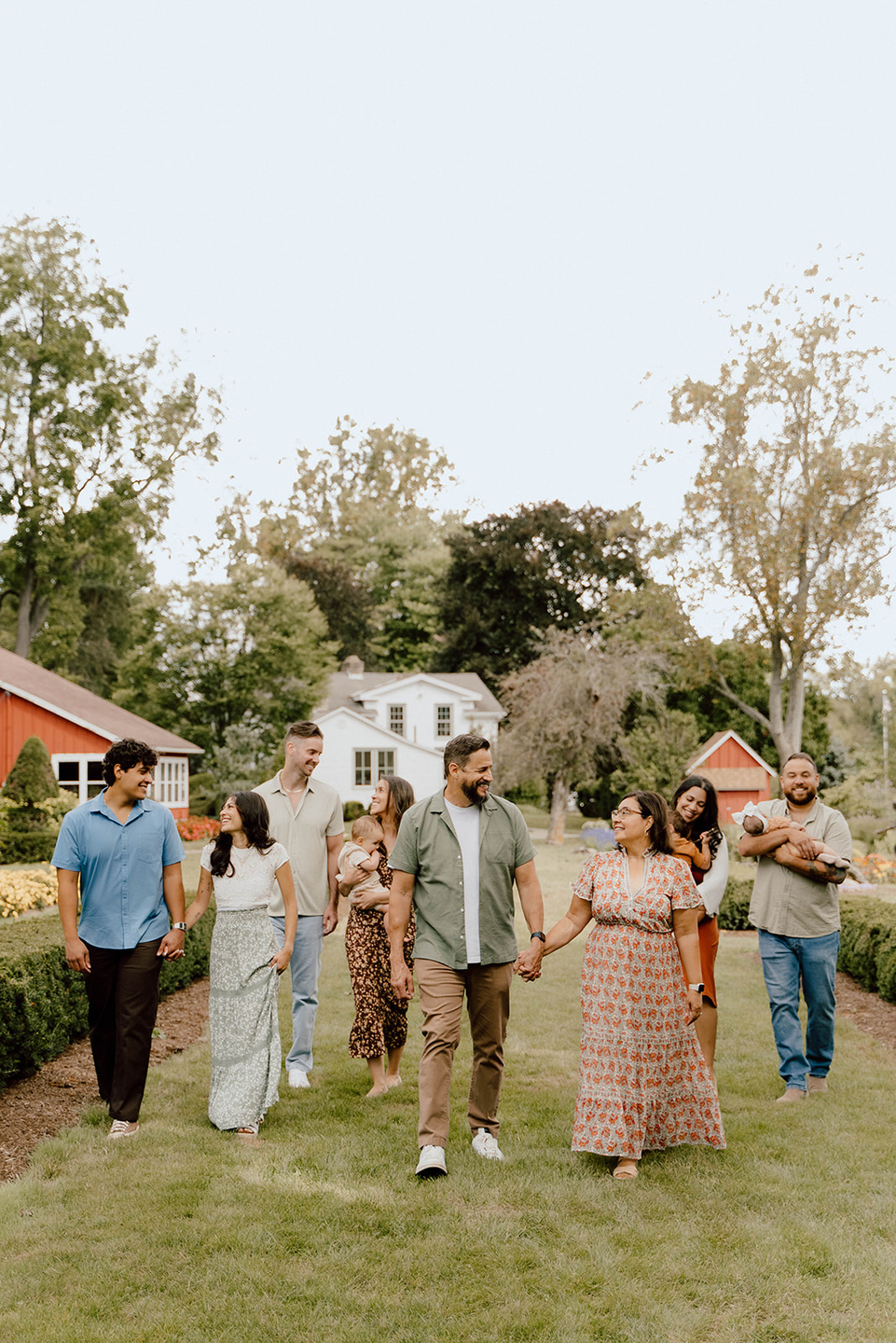 A large family walking arm in arm through a sunlit yard