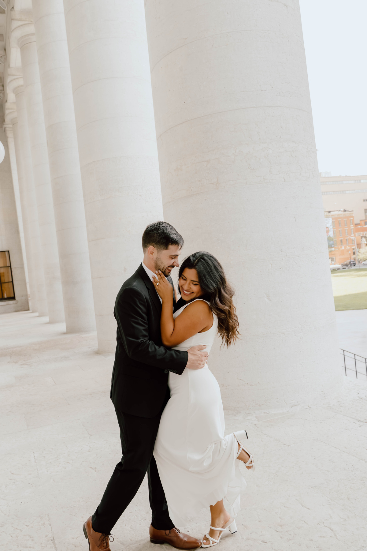 A couple holding each other beneath the Statehouse columns